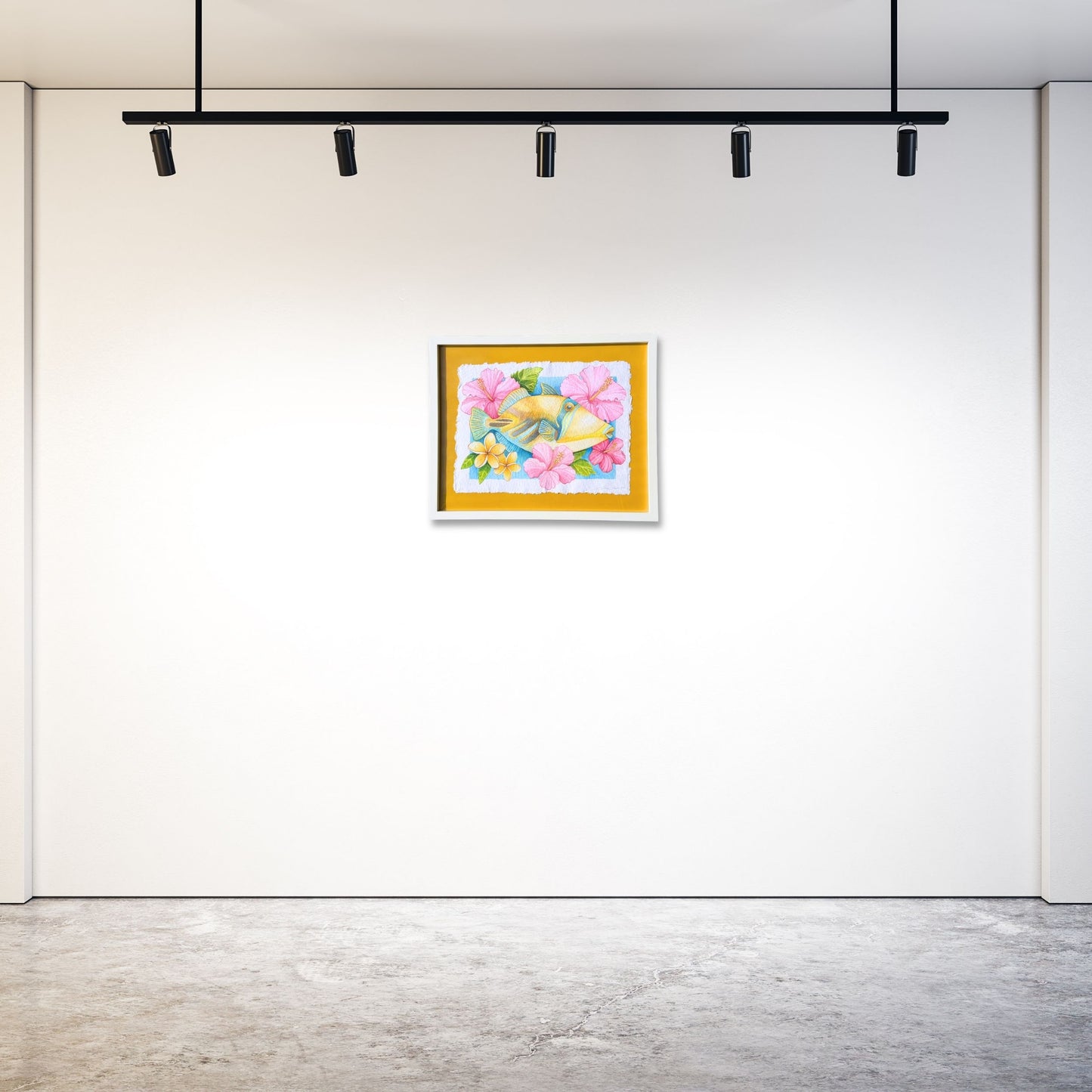Colorful watercolor painting on a white gallery wall with modern lighting fixtures. Original watercolor painting of Humuhumunukunukuapua'a in white frame of bright colorful yellow Trigger fish surrounded by pink botanical hibiscus flowers and yellow plumeria flowers on a yellow 
