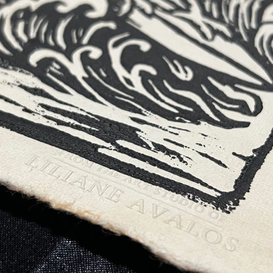 Close-up of a black and white abstract Surfing Rooster design with 'Liliane Avalos' branding custom emboss signature for authenticity. Artwork by Liliane Avalos, Kauai Hawaii artist